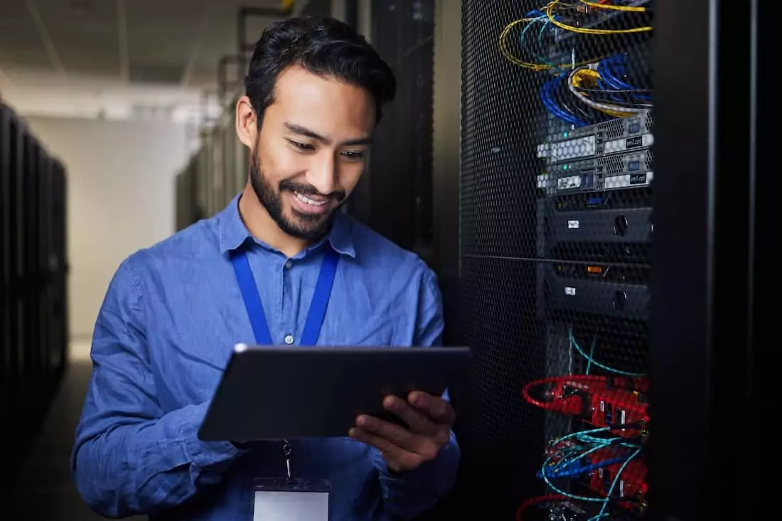 Técnico a monitorizar equipamentos numa sala de servidores